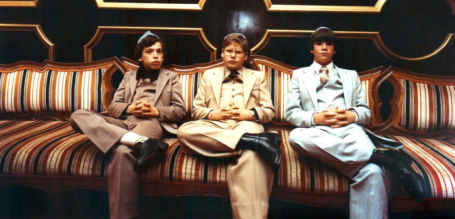 Three young men seated together in formal suits, a scene from Miami Beach Jewish life